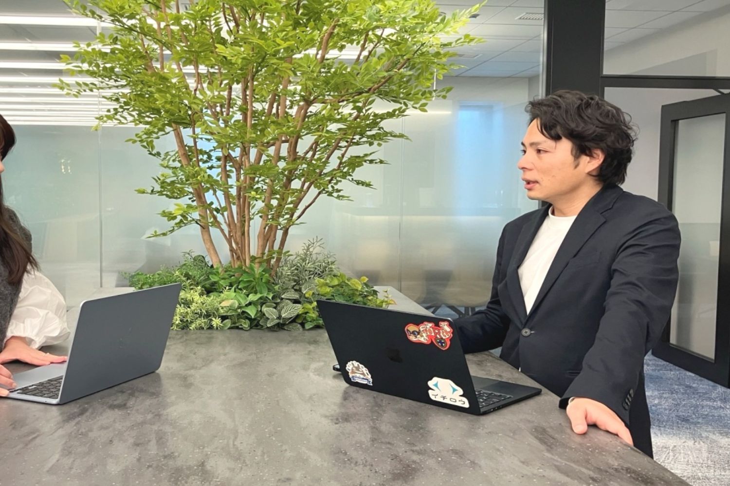 植栽を取り入れたオープンスペースでのコミュニケーション。空間のゆとりが、自然な発想や率直な意見交換を促します。